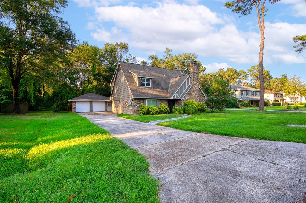 a view of a big house with a big yard and large trees