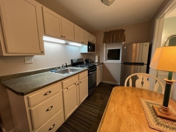 a kitchen with sink a stove and cabinets