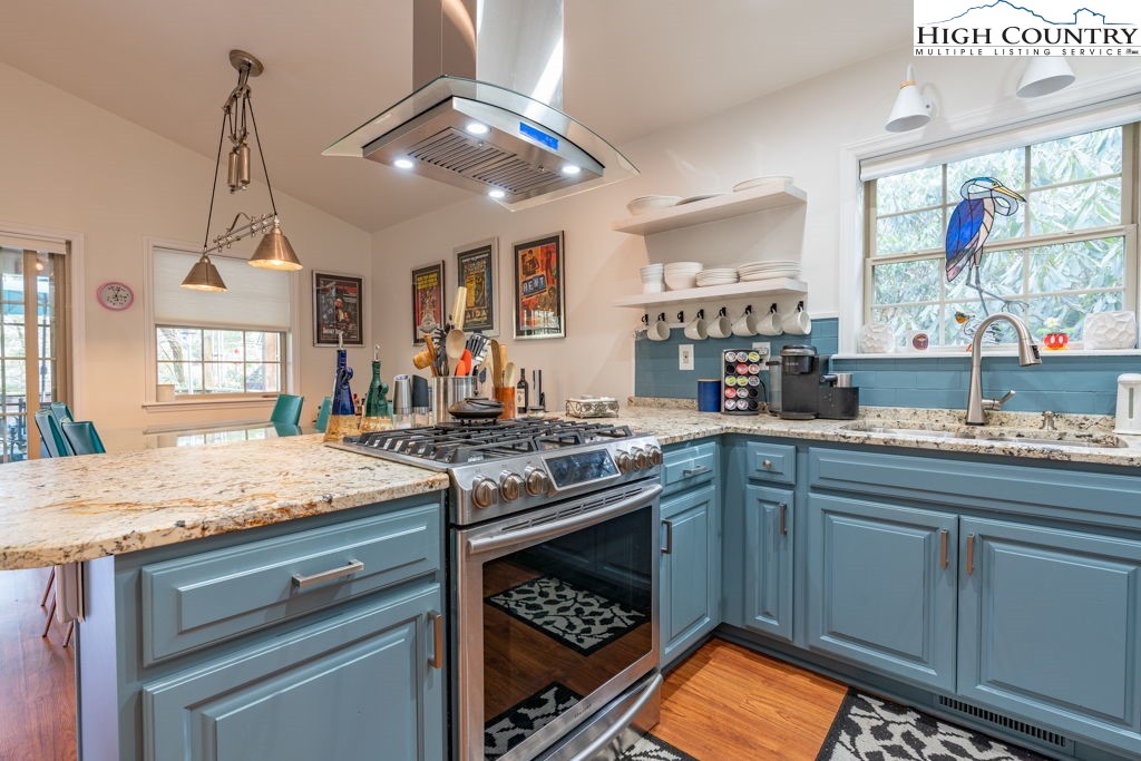 a kitchen with stainless steel appliances granite countertop a stove and cabinets