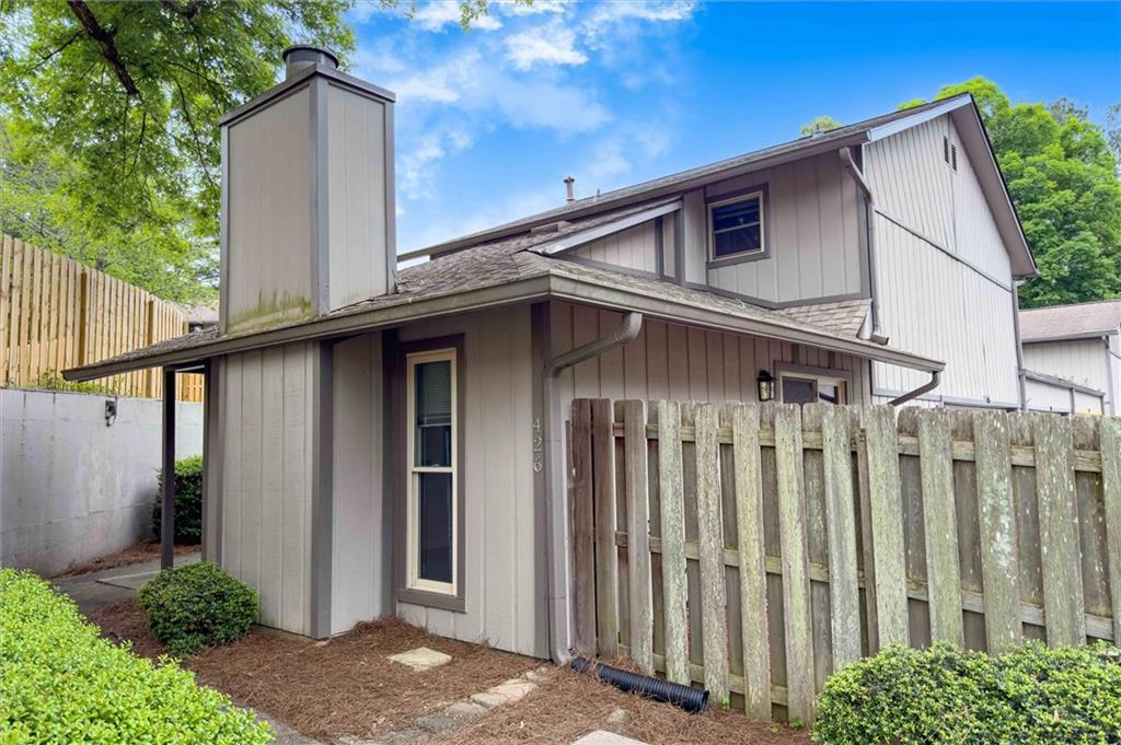 a view of a house with wooden fence