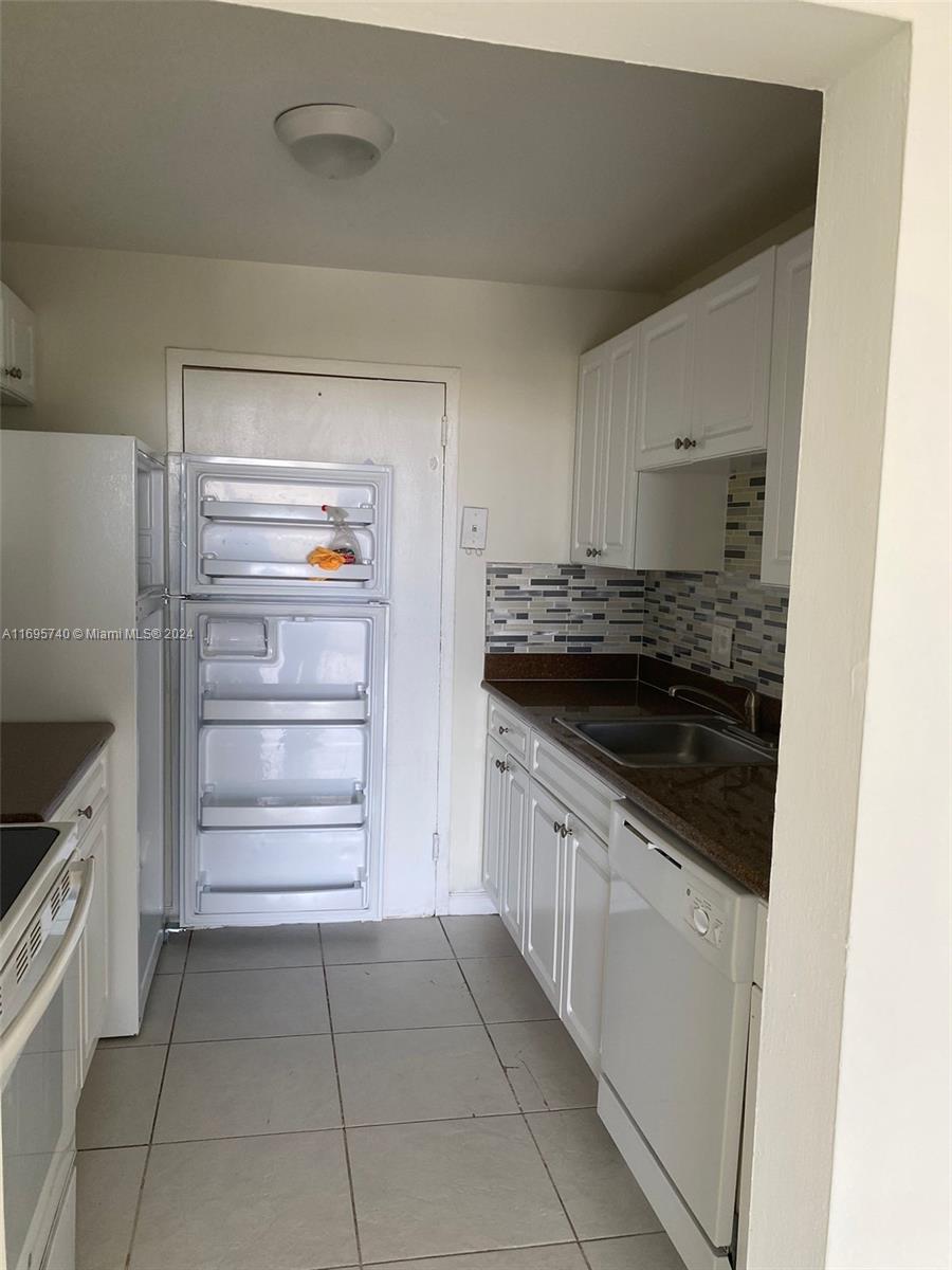 a kitchen with granite countertop a stove and a refrigerator