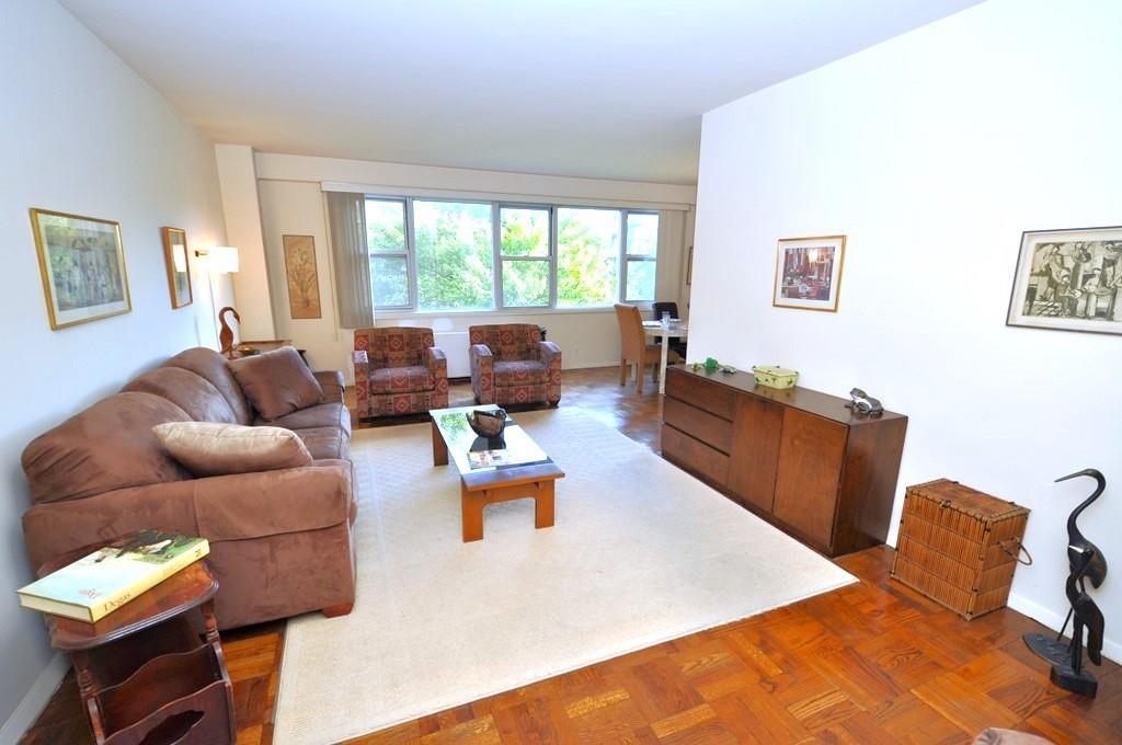 The oversized living room has a bank of windows with sunny Southern exposures and opens to the dining area and foyer.