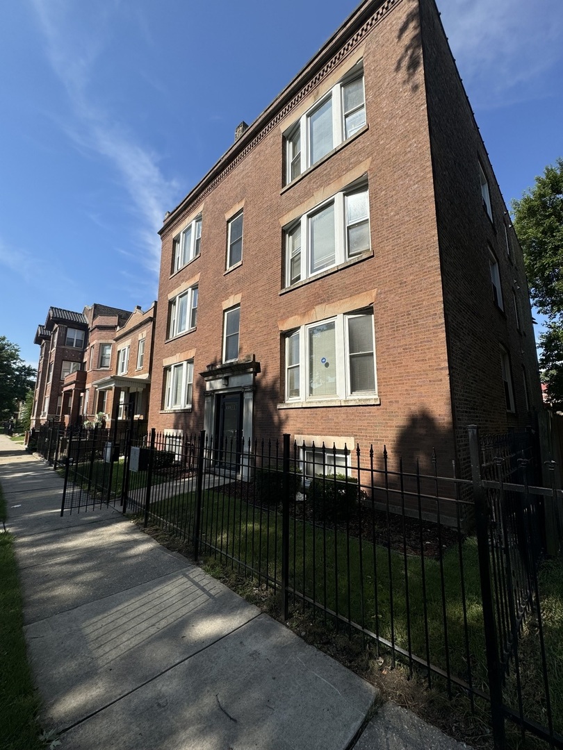 a view of a brick building next to a yard