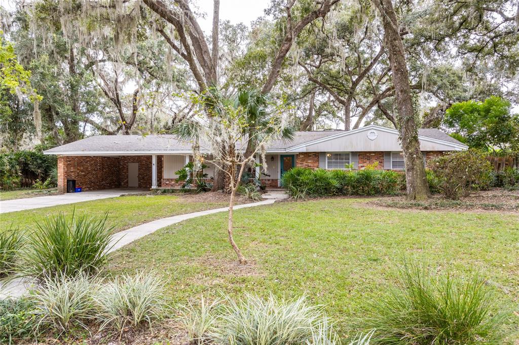 a front view of a house with a yard and trees