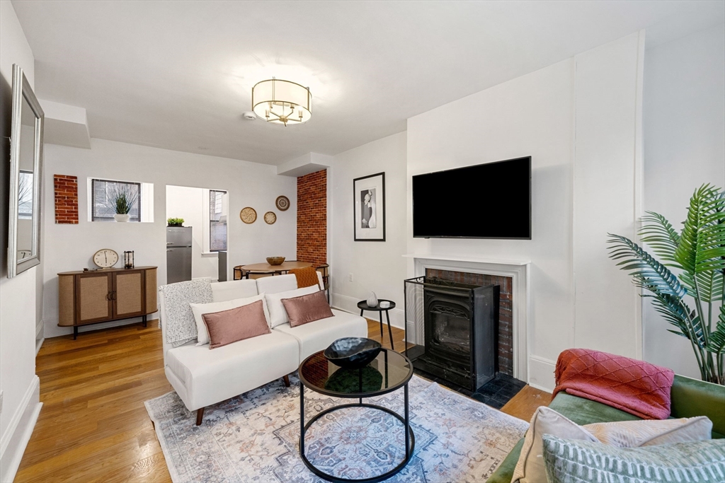 a living room with furniture a fireplace and a flat screen tv