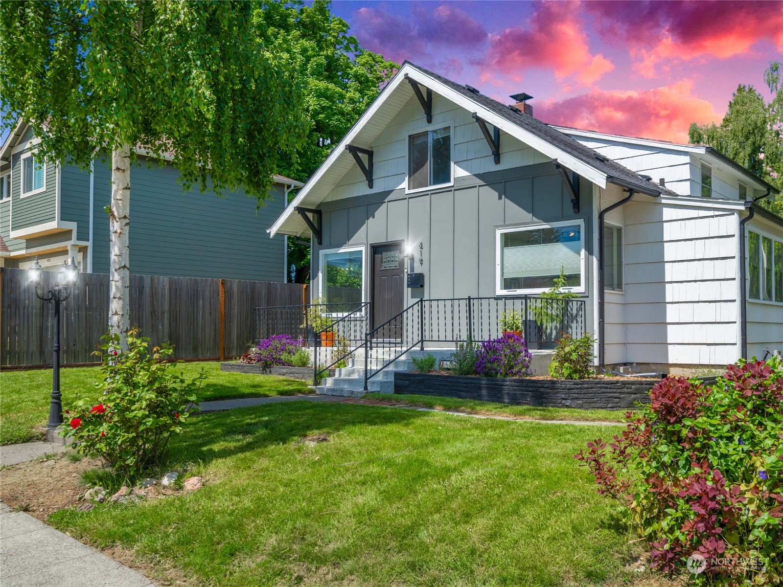 a front view of a house with garden and yard