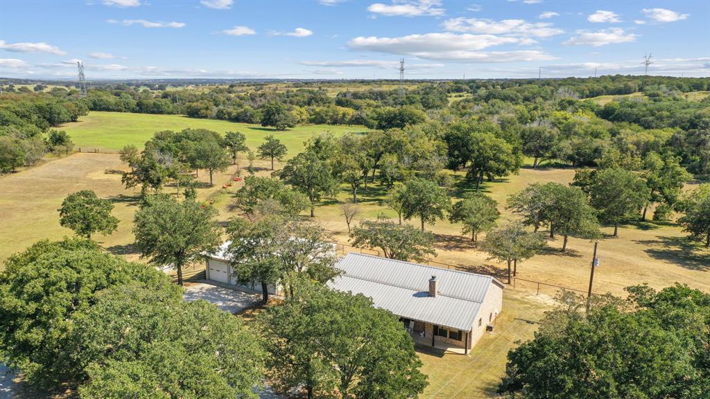 an aerial view of residential houses with outdoor space and trees