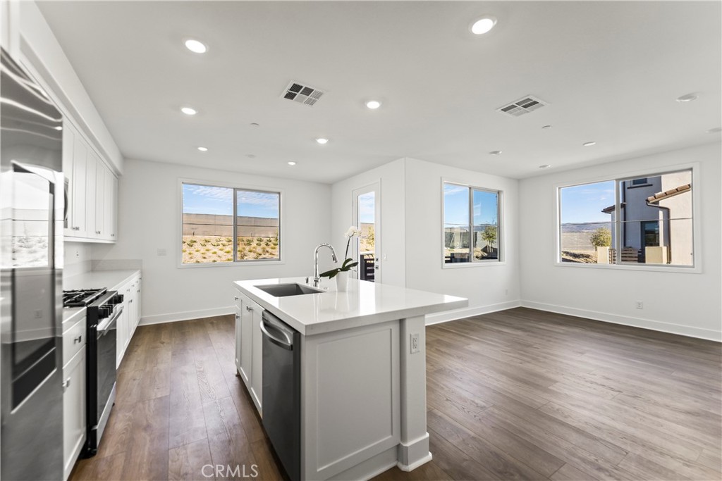 a kitchen with stainless steel appliances granite countertop a sink stove and wooden floor