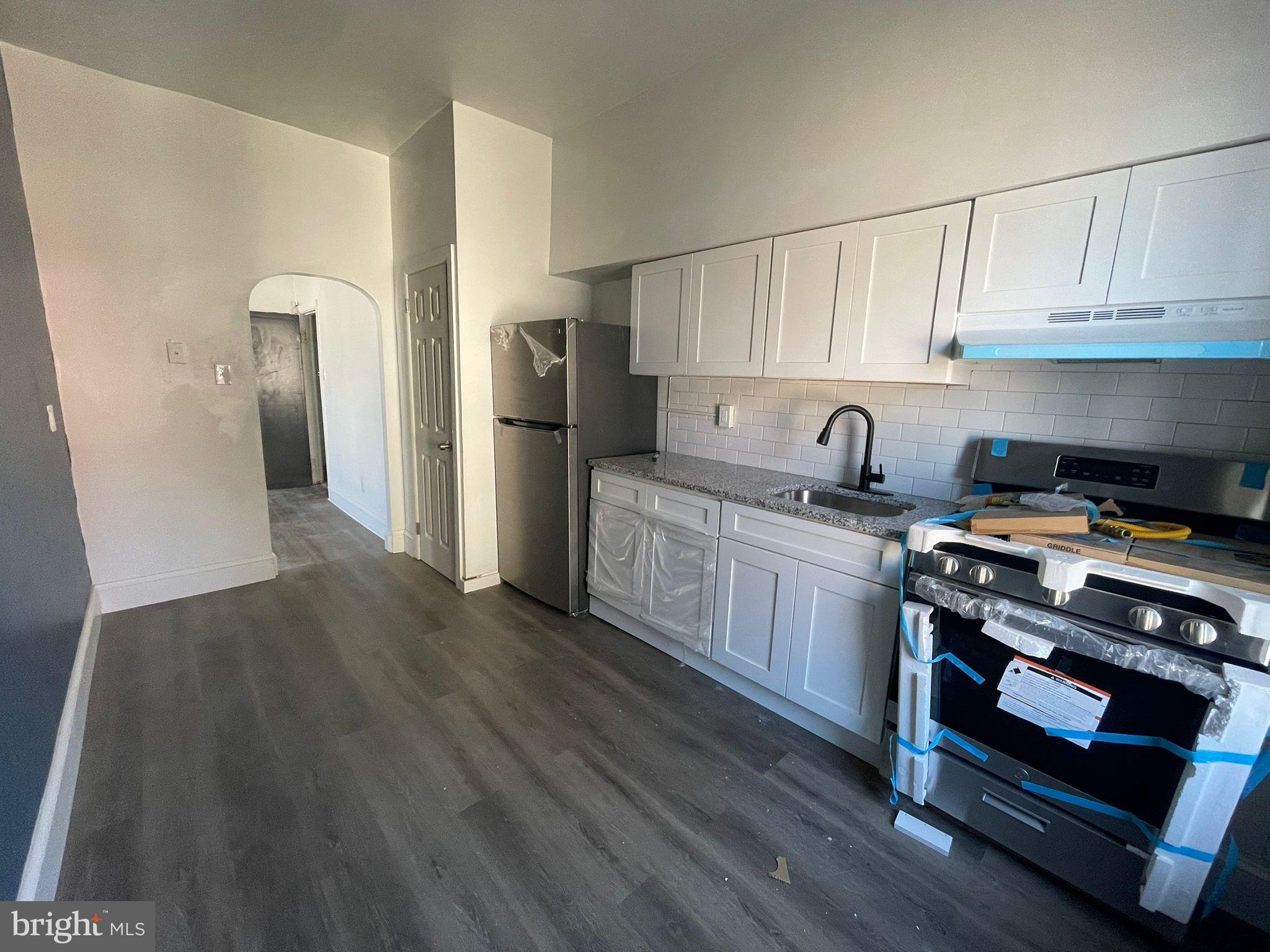 a kitchen with stainless steel appliances a stove a refrigerator and cabinets