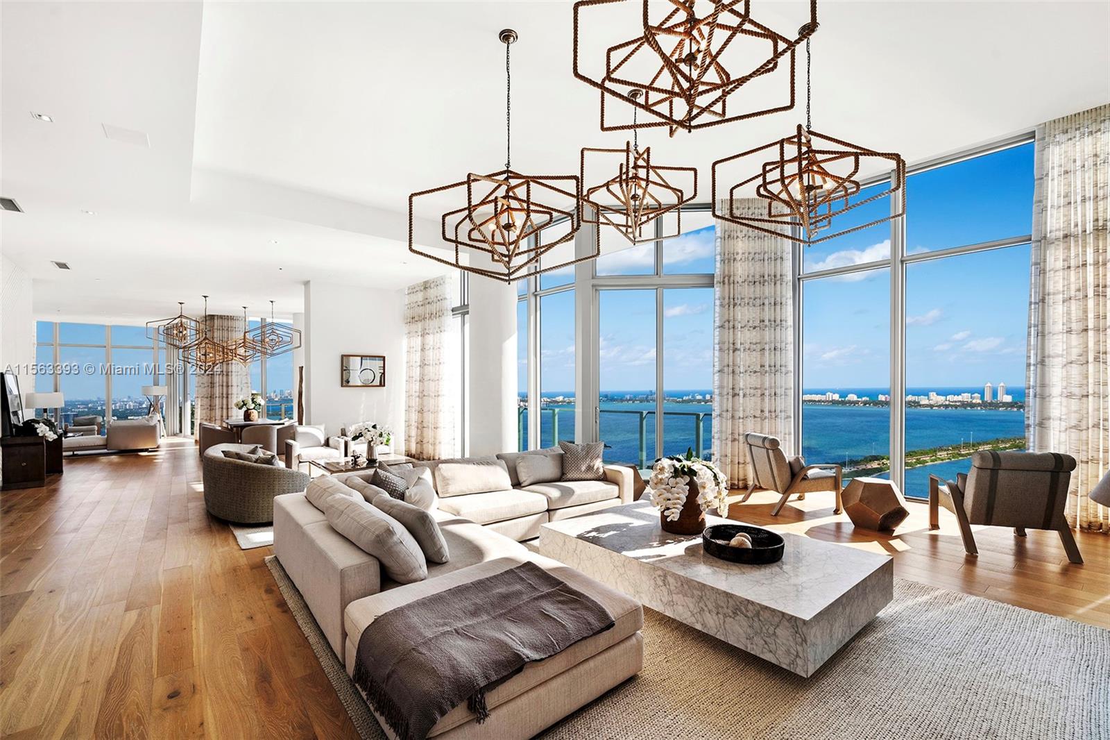 a living room with furniture and floor to ceiling windows