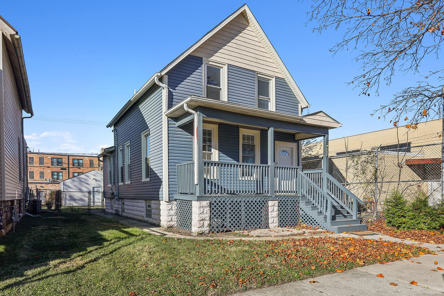 a view of a house with wooden fence next to a yard