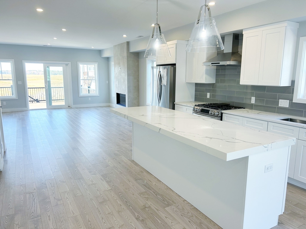 a kitchen with stainless steel appliances granite countertop a sink a stove and a wooden floors