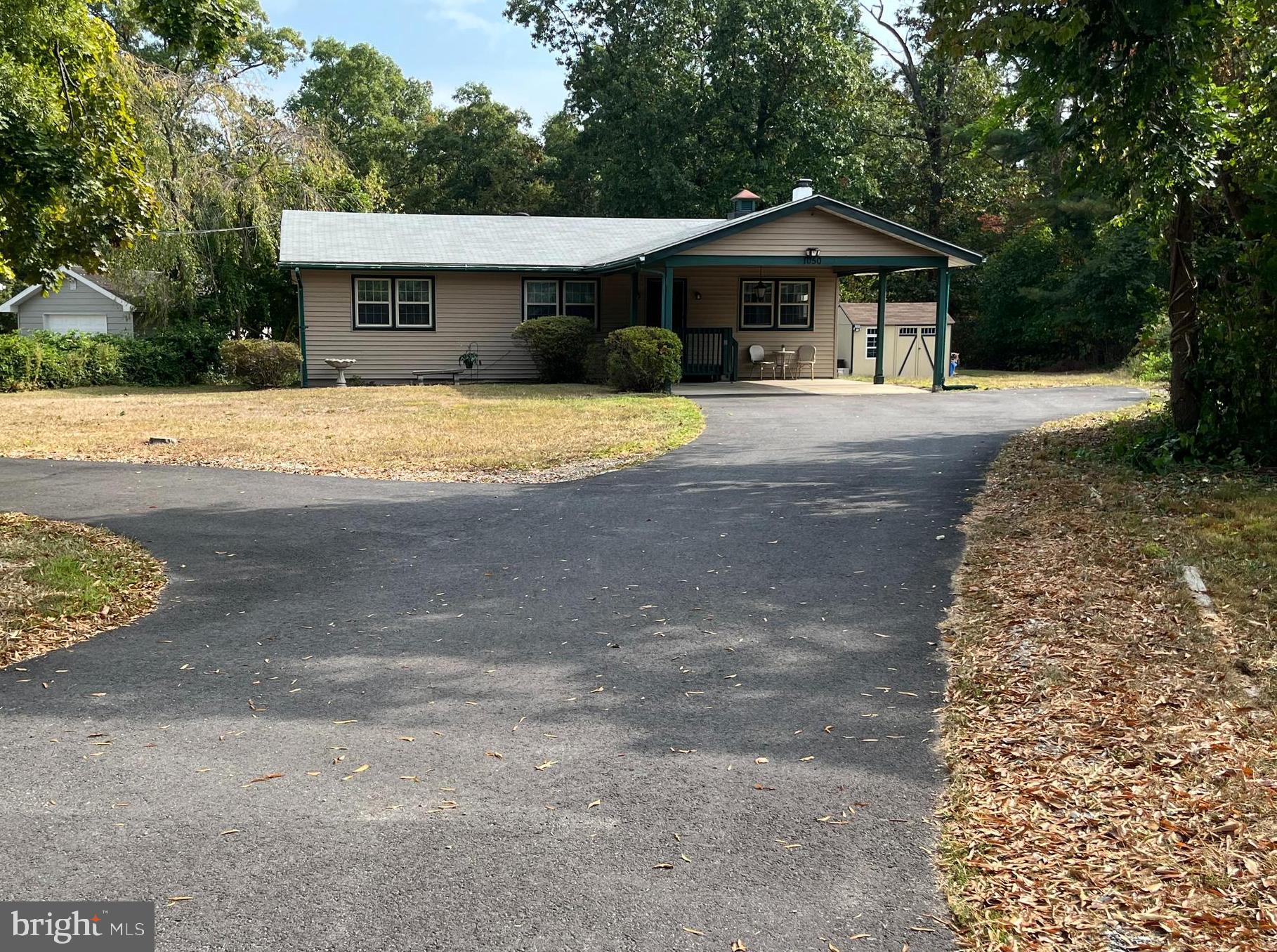 a front view of a house with a yard covered with trees