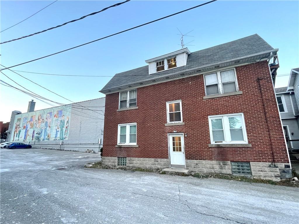 a brick house that has a lots of windows in it