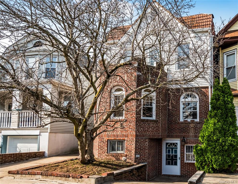 a front view of a house with a tree