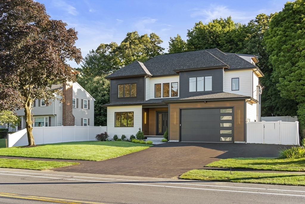 a front view of a house with a garden and garage