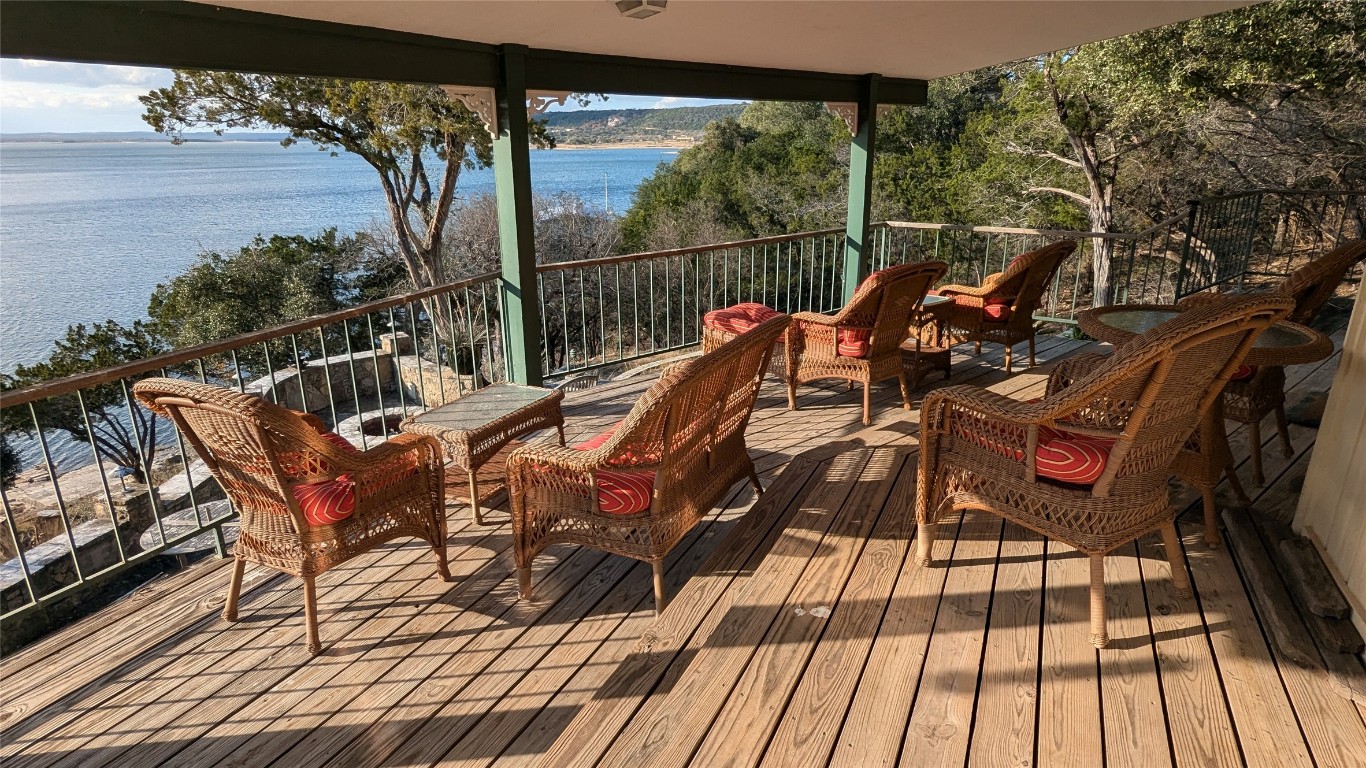 a view of a balcony with two chairs and wooden floor