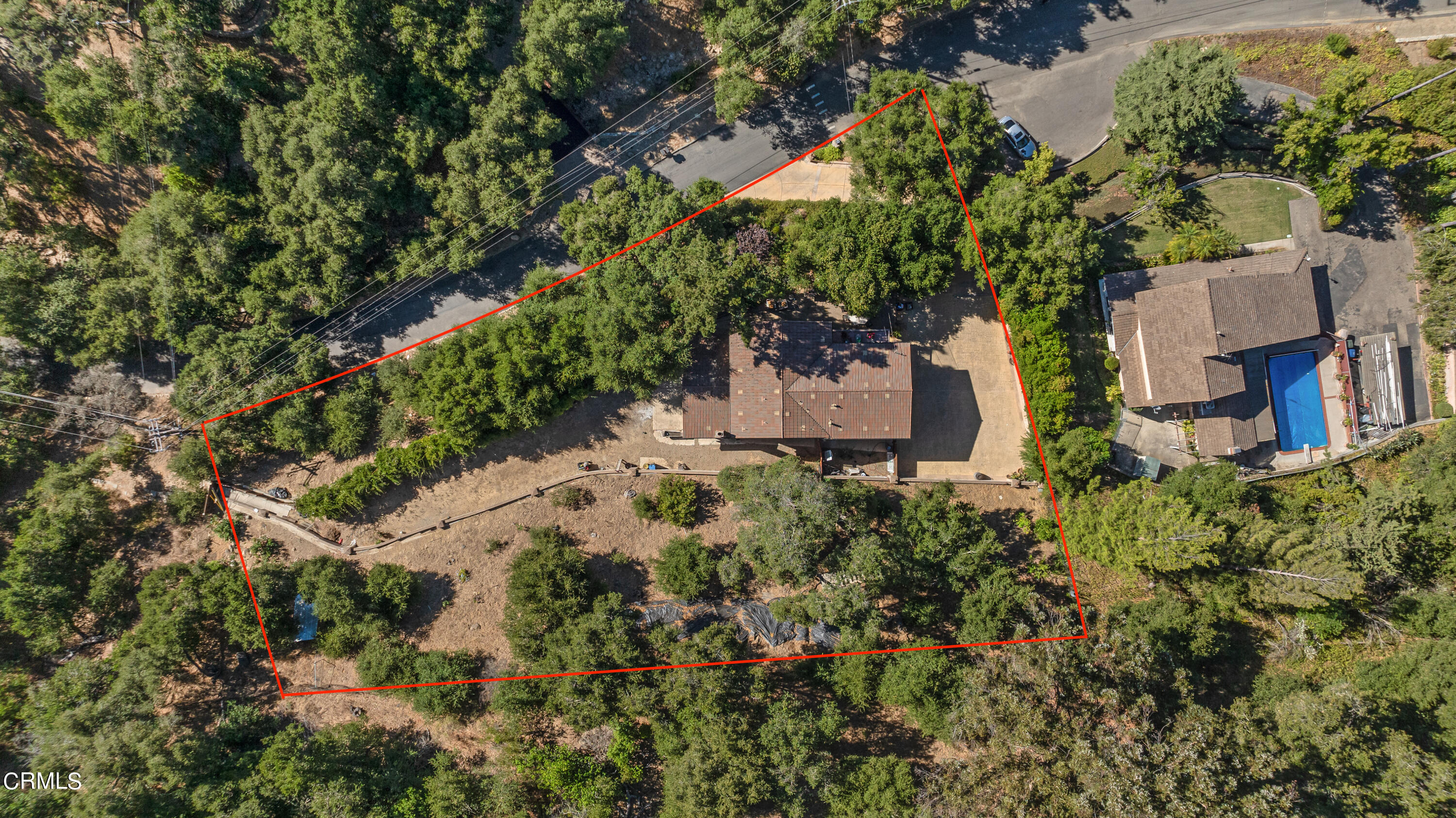 an aerial view of residential house with outdoor space and trees all around