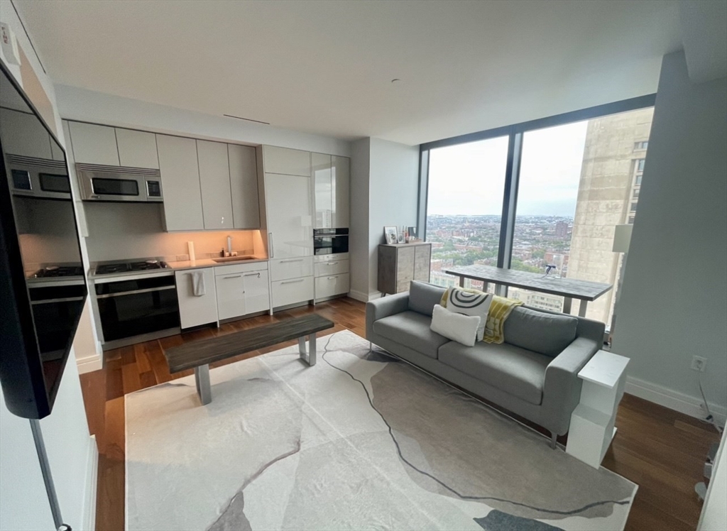 a living room with furniture and a floor to ceiling window