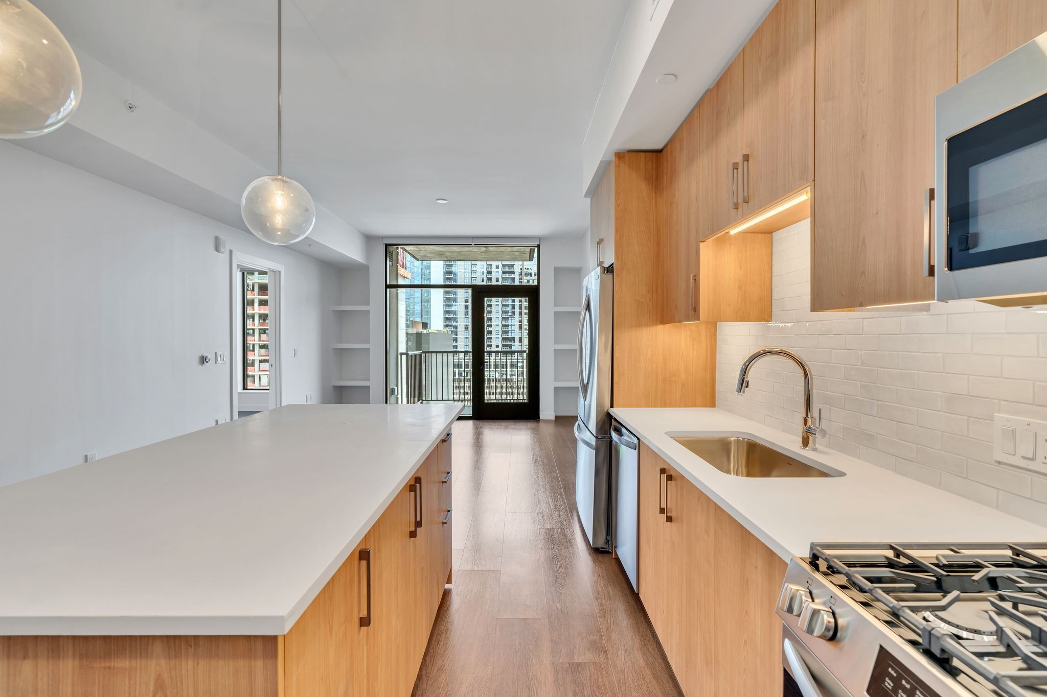 a kitchen with stainless steel appliances granite countertop a sink a stove and a wooden floors