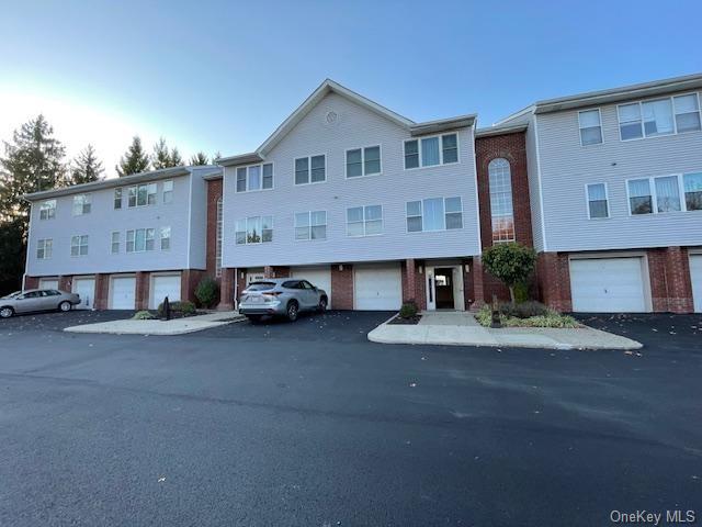 View of front of condo building featuring a garage