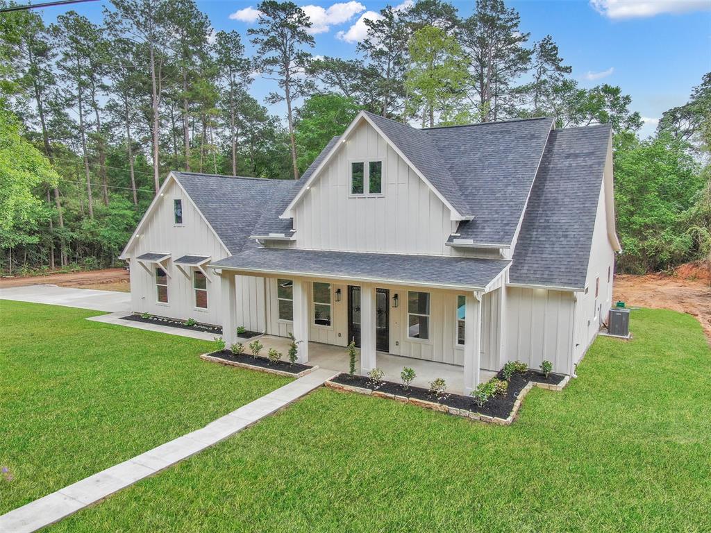 a front view of a house with a yard garden and patio