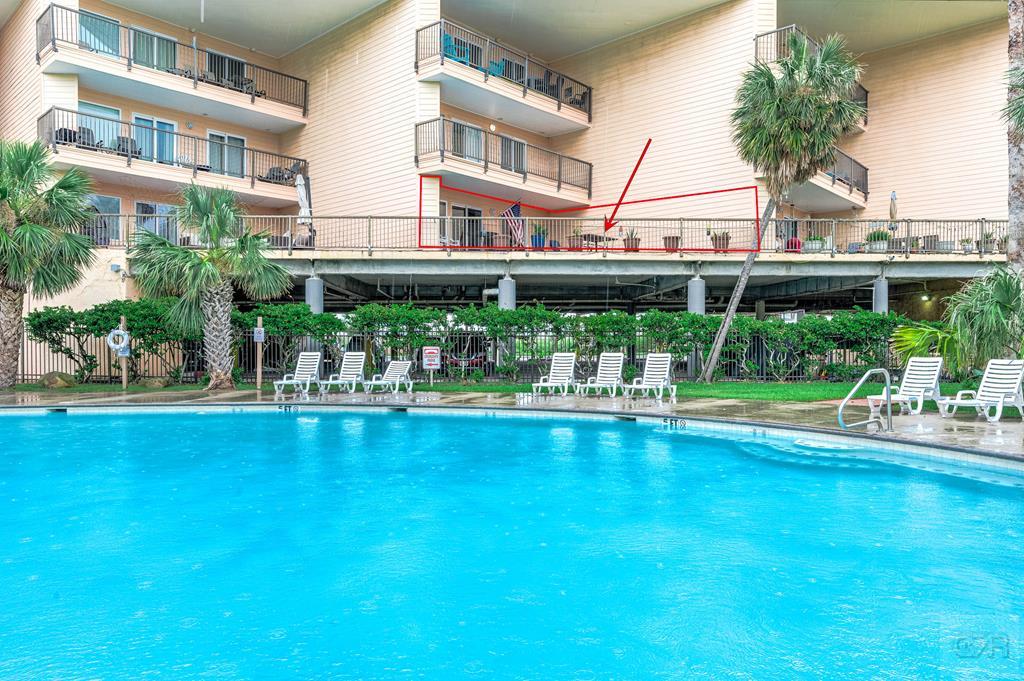 a view of pool with lawn chairs and plants