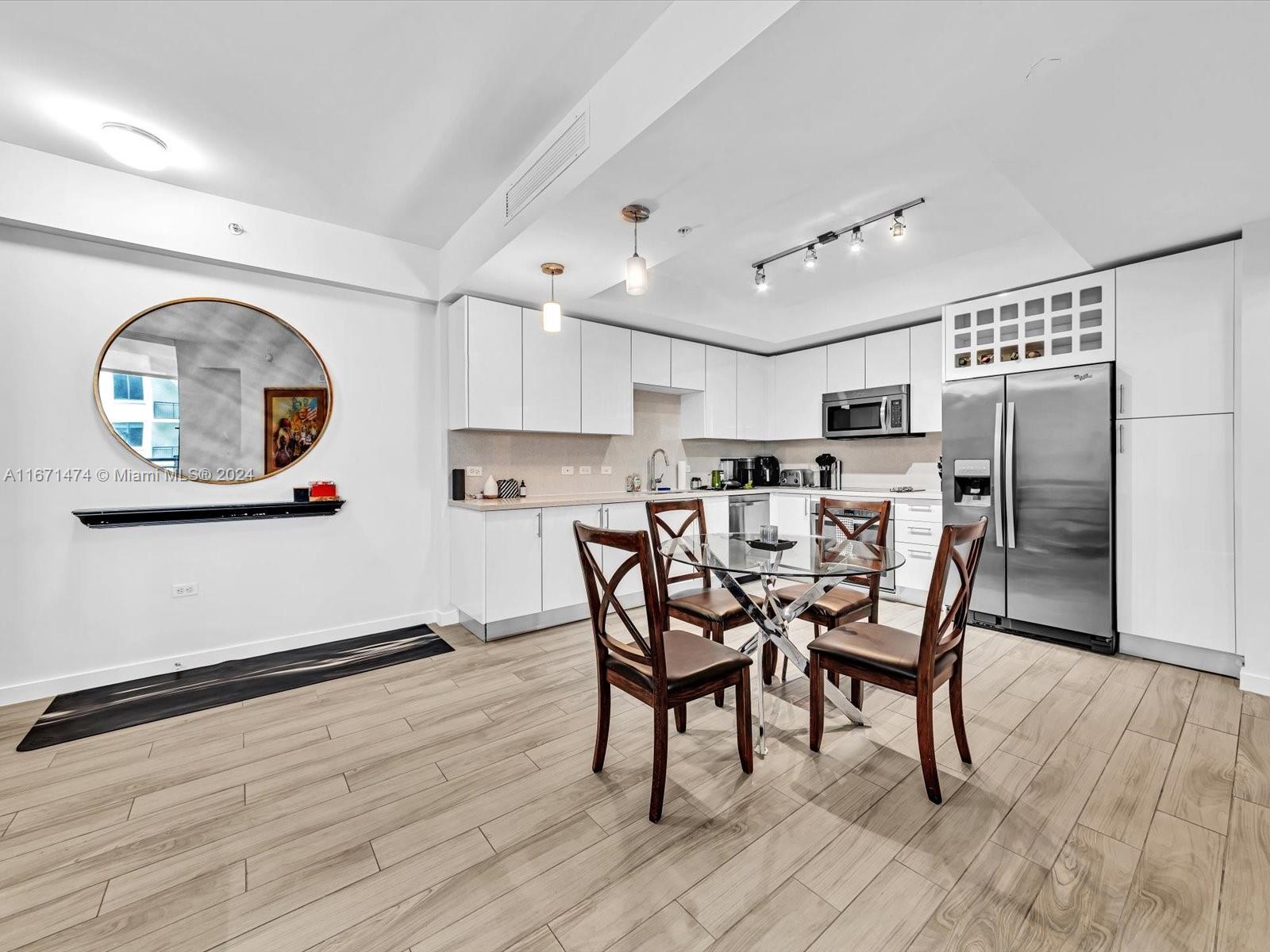 a kitchen with stainless steel appliances kitchen island a table and chairs in it