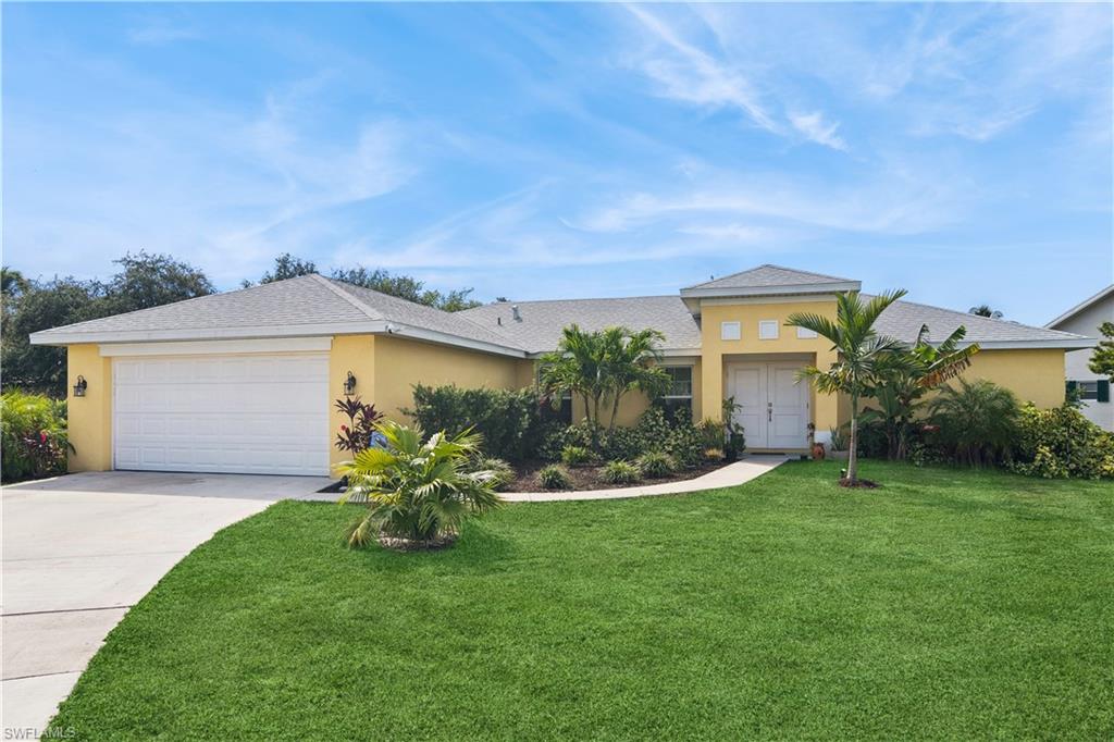 View of front of home with a garage and a front yard