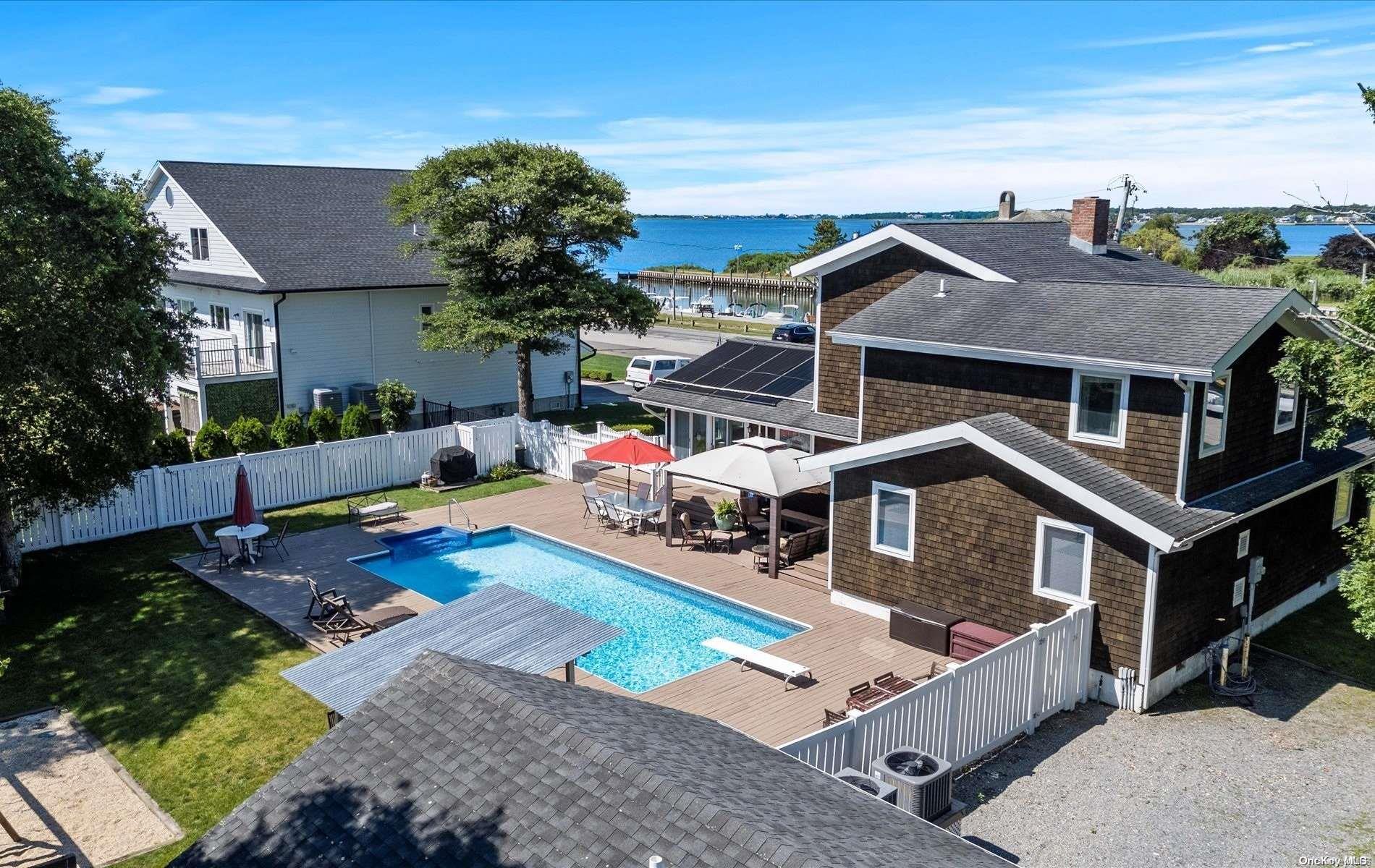 a view of a house with pool and chairs in patio