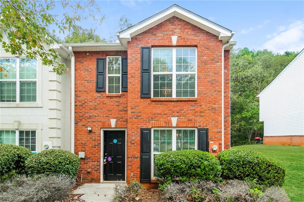 front view of a brick house with a yard