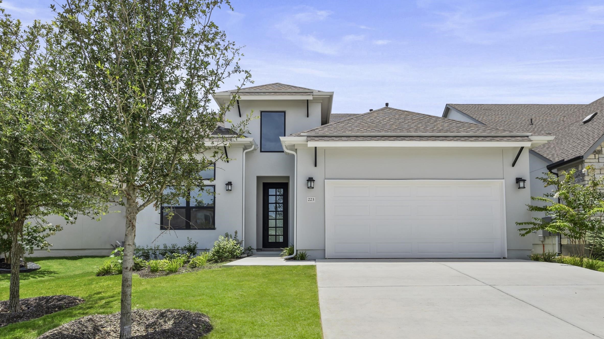 a front view of a house with a yard and garage