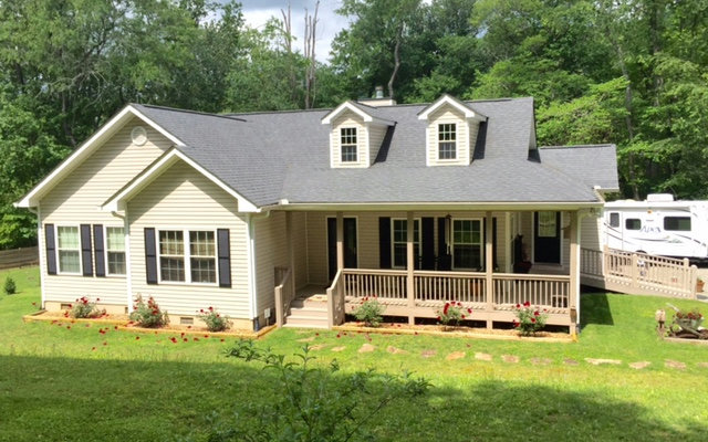 a view of a house with a yard and sitting area