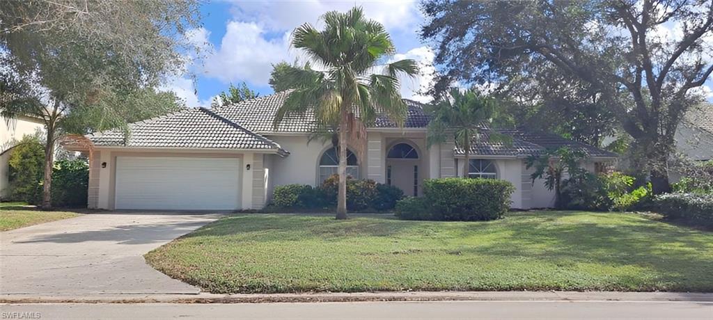 Mediterranean / spanish house with a garage and a front lawn