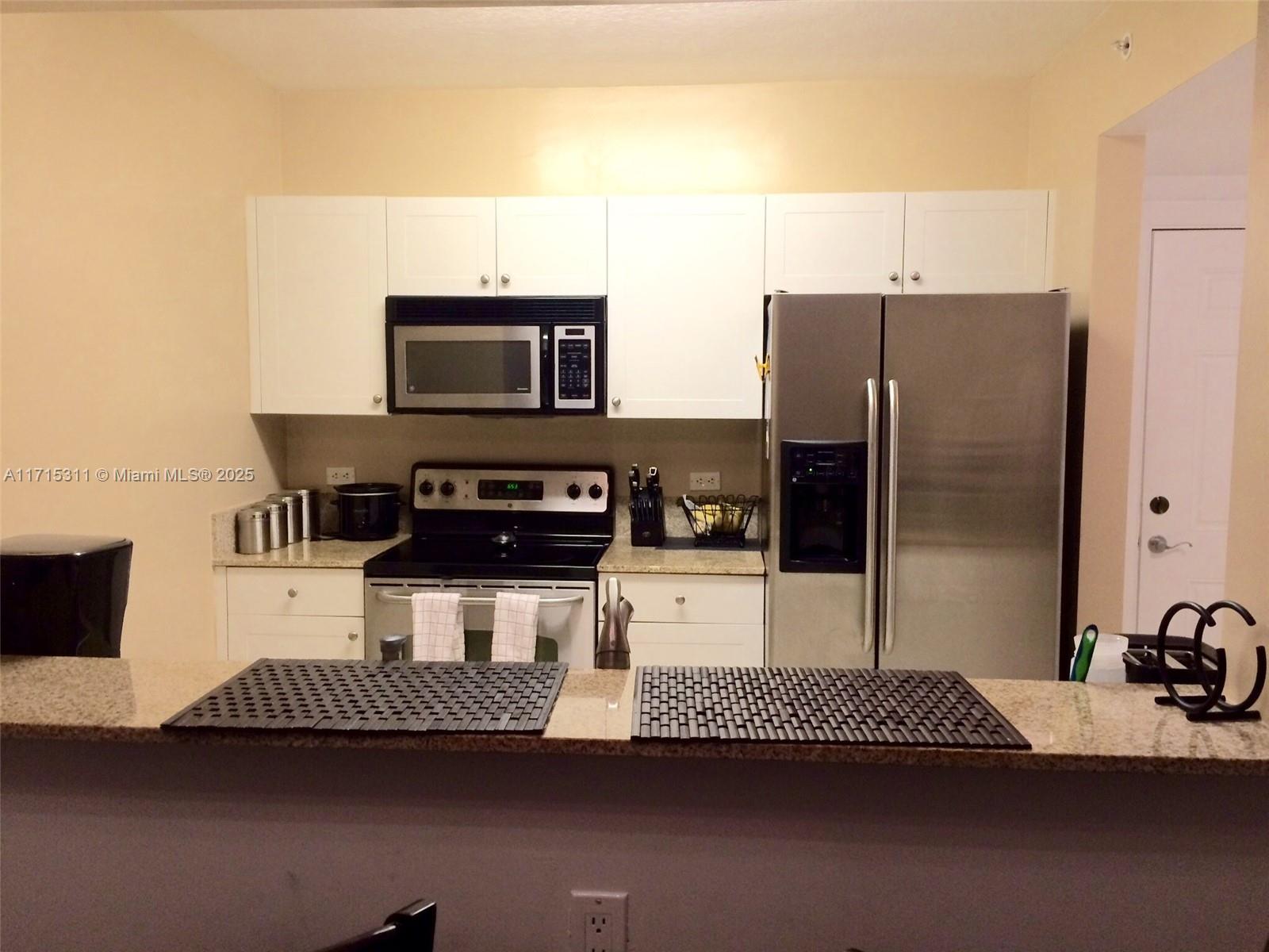 a kitchen with a refrigerator and a stove top oven