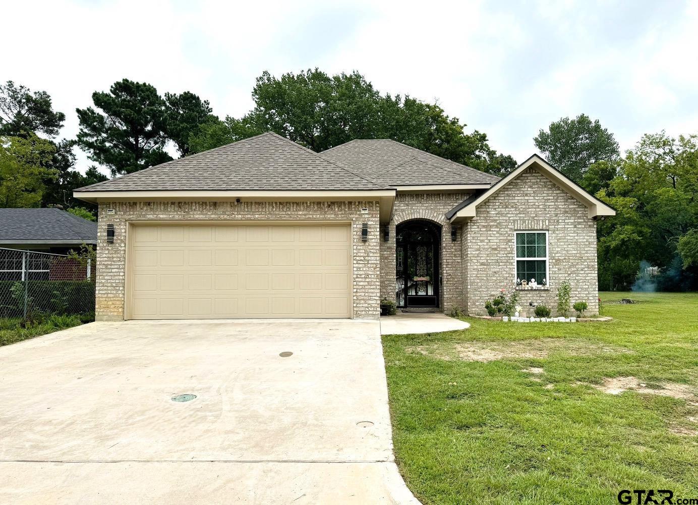 a front view of a house with a yard garage and outdoor seating