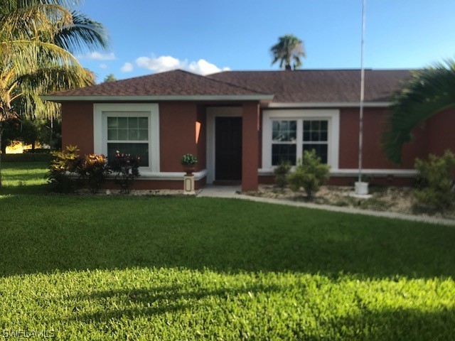 a front view of a house with a garden and plants