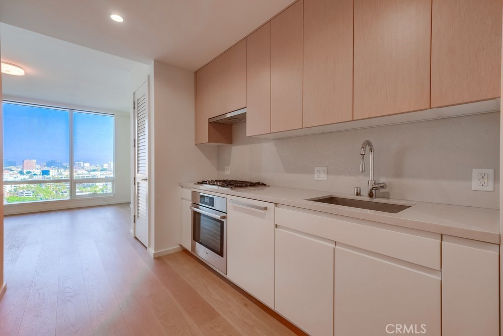 a kitchen with stainless steel appliances granite countertop a sink a stove and cabinets