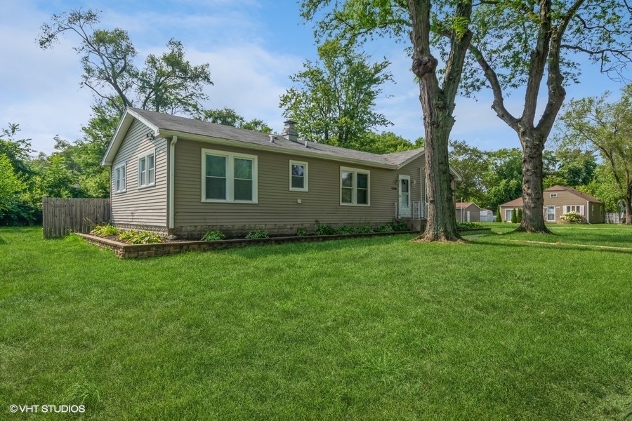 a view of a house with yard and tree s