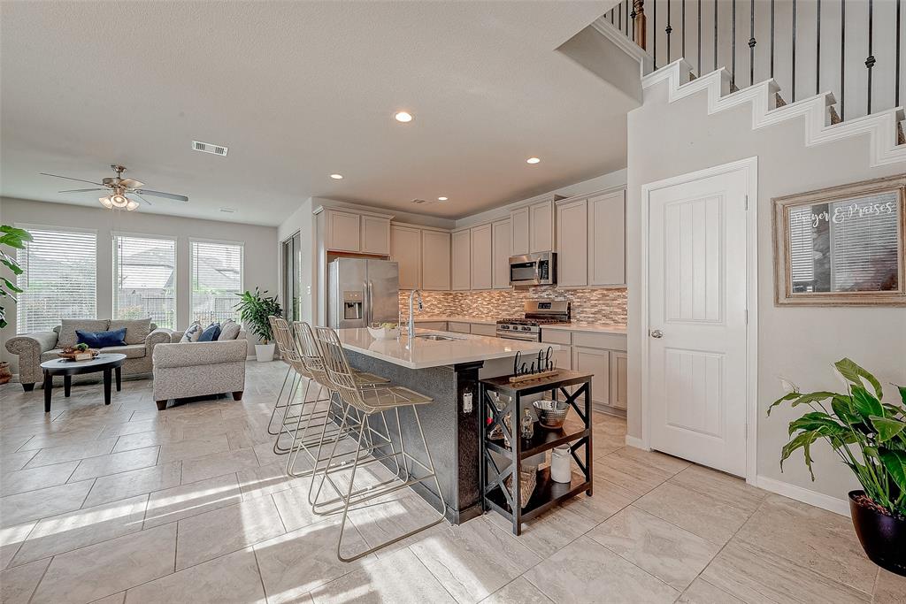 a kitchen with kitchen island a counter top space a sink stainless steel appliances and cabinets