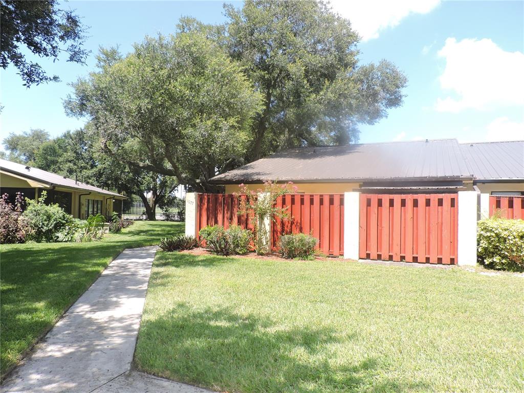 a view of a house with a yard and pathway