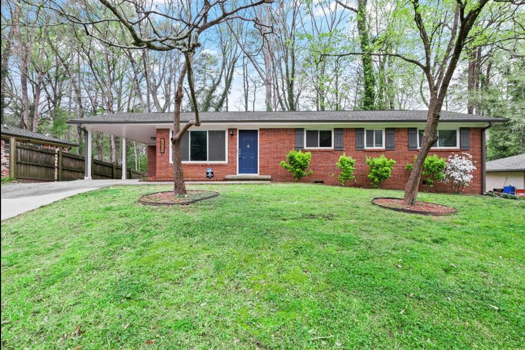 front view of a brick house with a yard