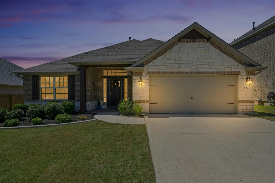 a front view of a house with a yard and garage