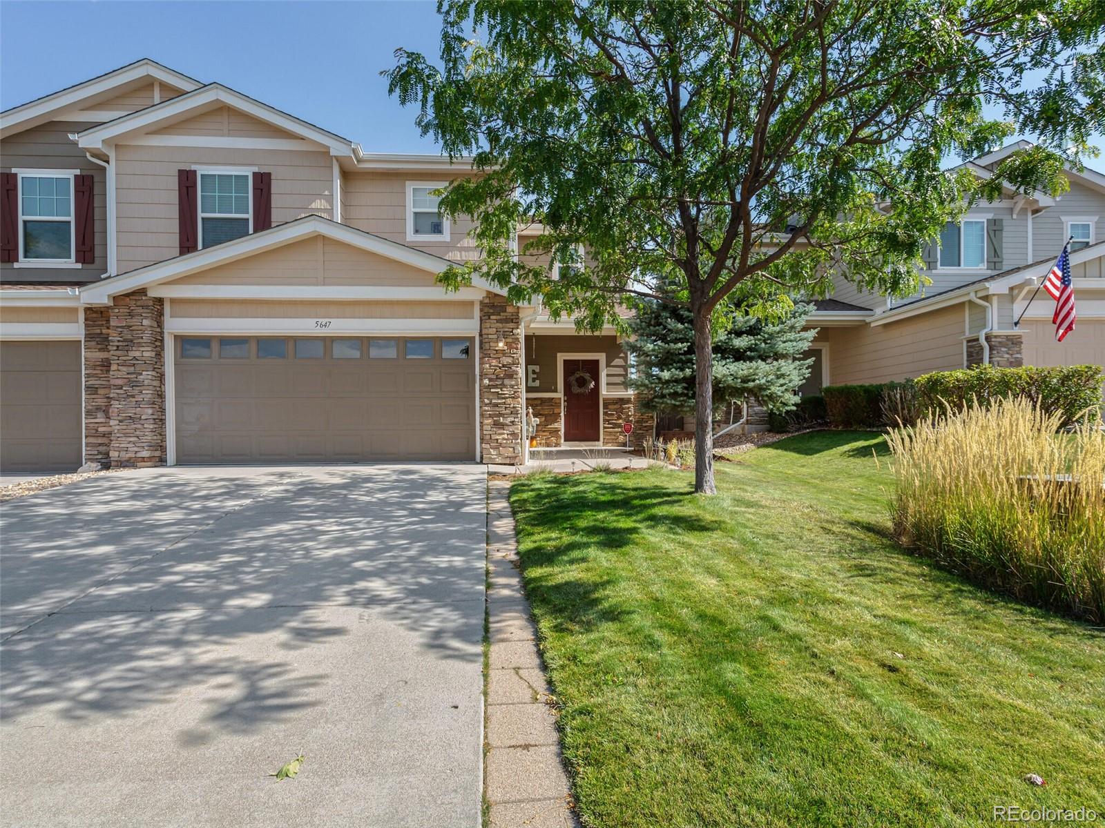 a front view of a house with a yard and trees