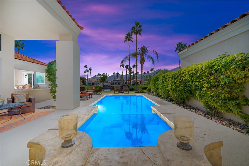 a swimming pool with outdoor seating and yard