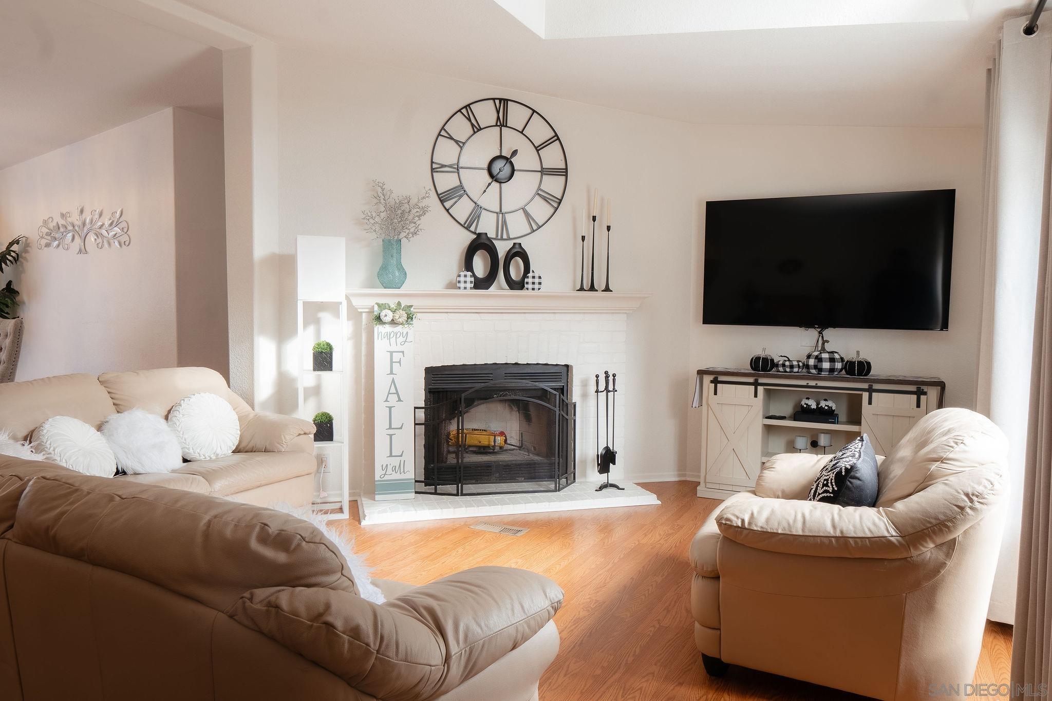 a living room with furniture a flat screen tv and a fireplace