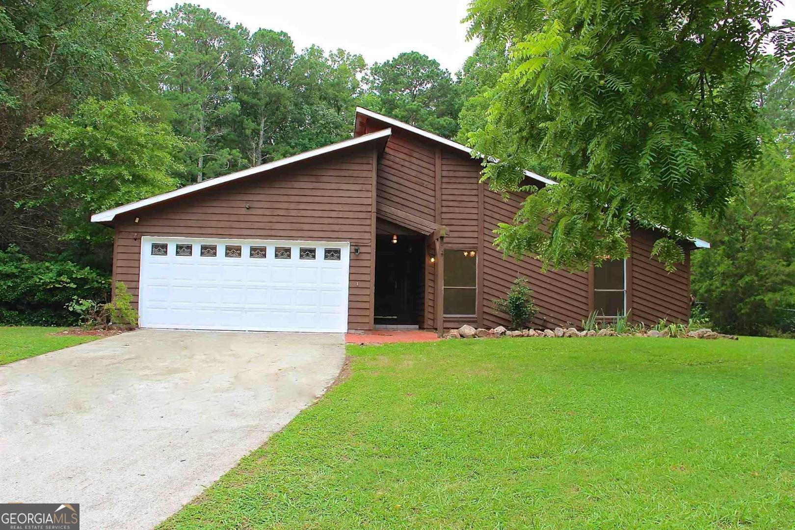 a view of a house with a yard and garage