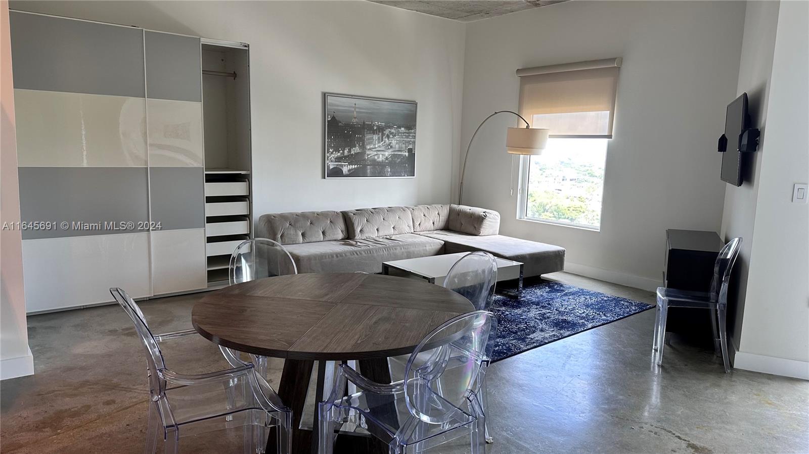 a view of a dining room with furniture and a window