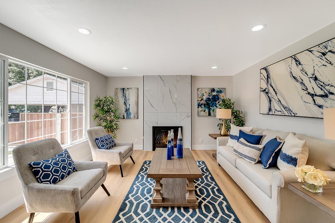 a living room with furniture a fireplace and a floor to ceiling window