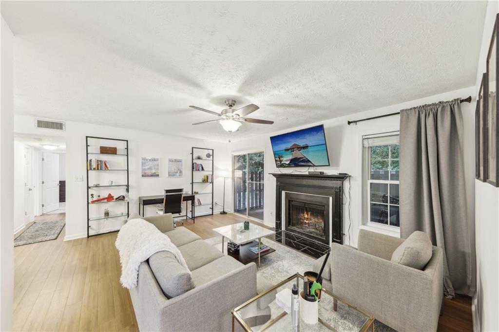 a living room with furniture fireplace and a large window